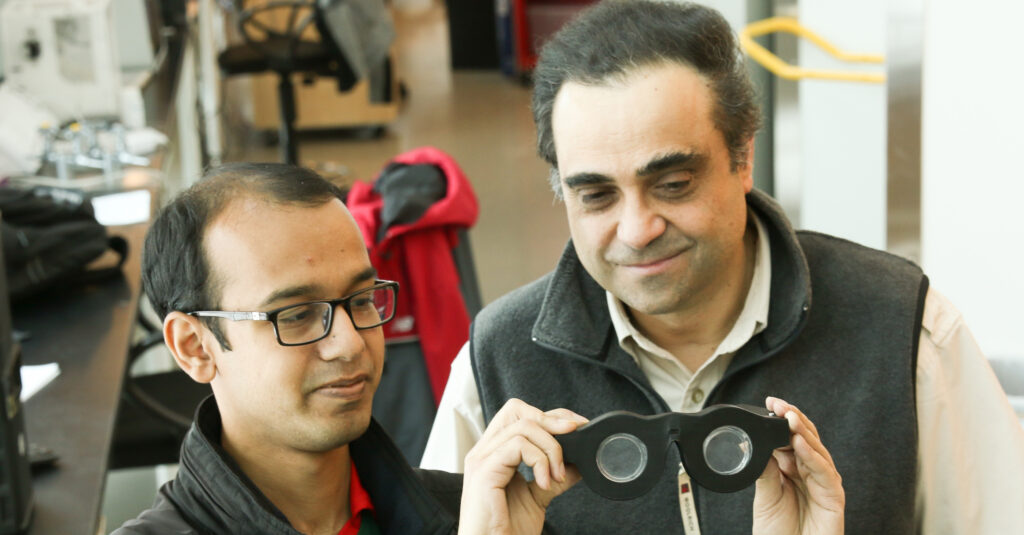 Carlos and Nazmul checking out their specs. Source. 