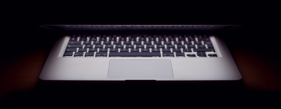 laptop half-closed against a dark background