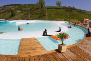 urbnsurf in melbourne with wooden benches, blue and white water and green hills on a sunny day