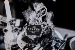 Katherine Sabbath's Christmas Coal collaboration with Kraken rum wrapped up in plastic with black white and grey background